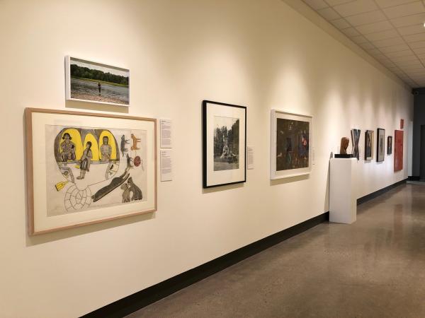 Installation view of From Her Perspective showing an array of small and medium sized framed works on a white wall